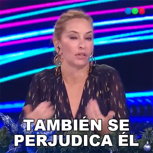 a woman says tambien se perjudica el in front of a christmas tree