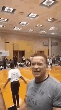 arnold schwarzenegger is wearing an american eagle t-shirt in a gym