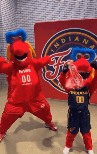 two indiana mascots are dancing in front of a sign that says indiana