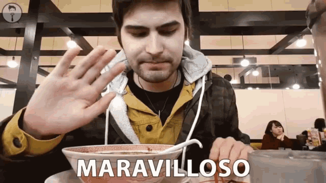a man sitting at a table with a bowl of food and the word maravilloso written on it