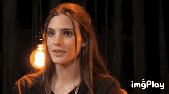 a woman with a light bulb behind her and the words imgplay on the bottom right