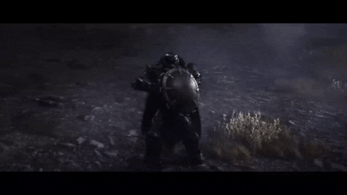 a person in a helmet is standing in the dark in a field .