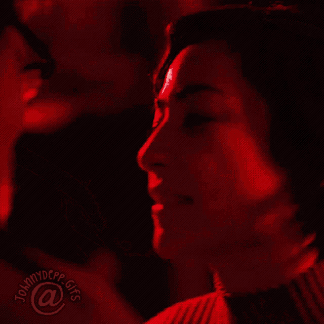 a man and a woman kissing in a red light with johnnydepp gifs @ a