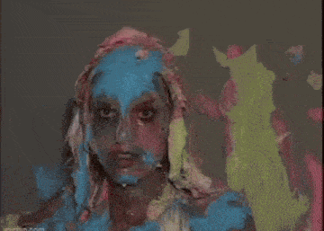a woman is covered in a bunch of different colors of paint .