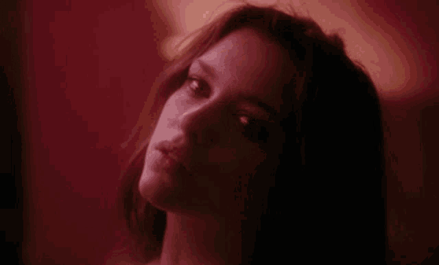 a close up of a woman 's face with a red background .