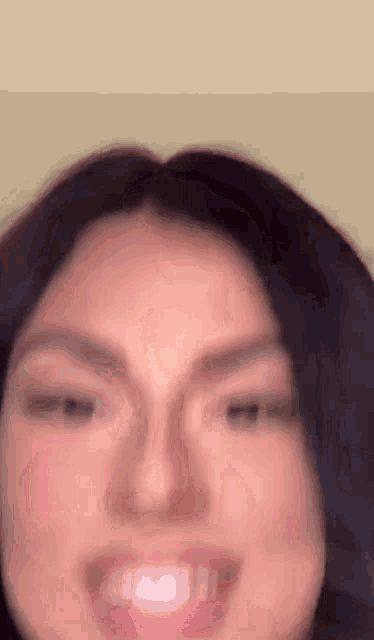 a close up of a woman 's face with her eyes closed and a smile on her face .