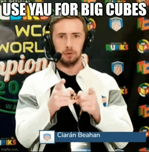 a man wearing headphones is pointing at the camera with the words `` use yau for big cubes '' written above him .