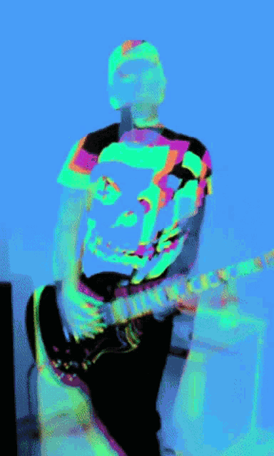 a man wearing a shirt with a face on it is playing an electric guitar