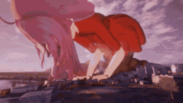 a girl with pink hair and a red shirt is kneeling down on a rock .