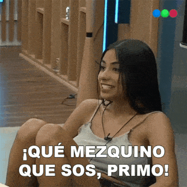 a woman sitting on the floor with the words que mezquino que sos primo written below her