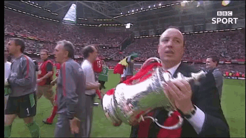 a man is holding a trophy in front of a bbc sport screen