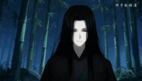 a man with long black hair is standing in a forest