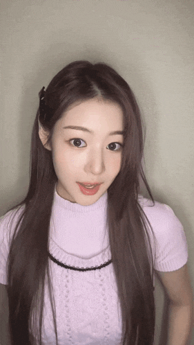 a woman with long hair is wearing a purple sweater