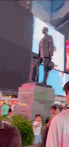 a blurry picture of a statue of a man sitting on a pedestal