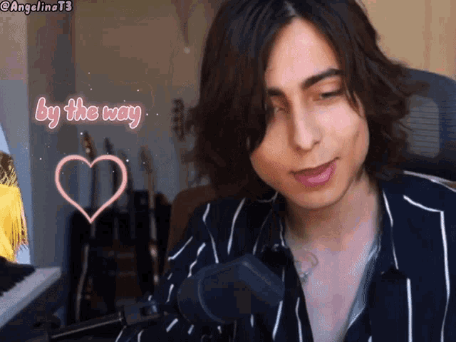 a man in a striped shirt is sitting in front of a microphone with a heart and the words by the way above him