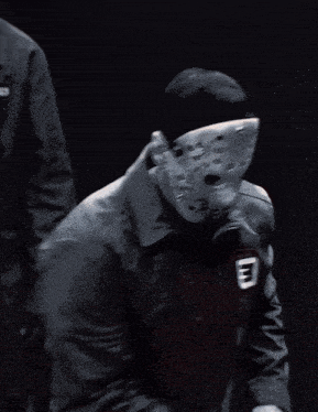 a man wearing a mask and a jacket with the letter e on his chest