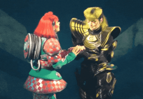 a woman with red hair is holding hands with a man in a black suit with a g on his chest