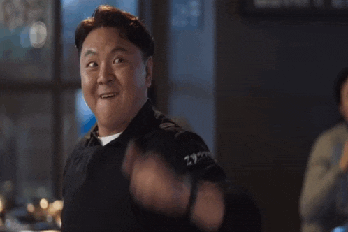 a man is making a funny face with his fist in the air while wearing a watch .