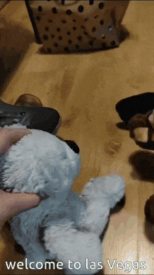 a person is petting a white teddy bear that says welcome to las vegas on the bottom