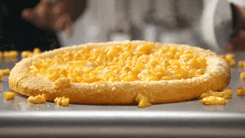 a macaroni cheese pizza is sitting on a pan