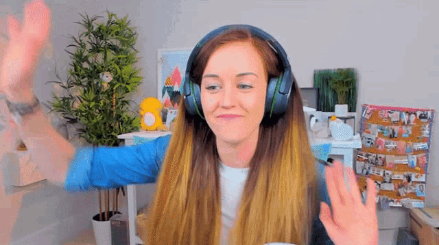 a woman wearing headphones is giving a high five to someone