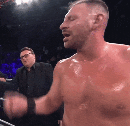 a man without a shirt is standing in a boxing ring with his eyes closed