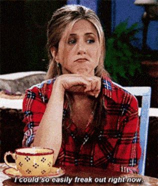 a woman in a plaid shirt is sitting at a table with a cup of tea and a saucer .