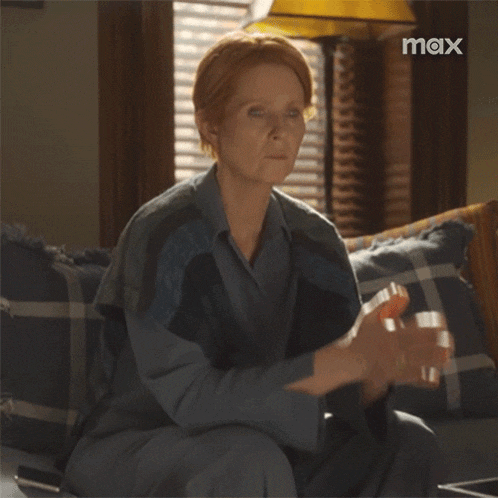 a woman sitting on a couch with a max logo in the background