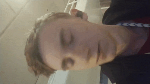 a close up of a person 's face with their eyes closed and a red shirt on