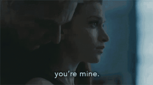 a man and a woman are looking at each other and the woman is saying `` you 're mine . ''
