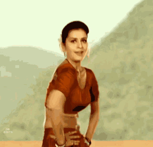 a woman in a red crop top is standing in front of a mountain