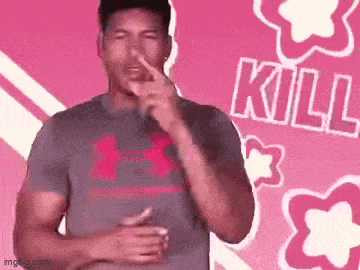 a man in a grey under armour shirt is holding his nose .