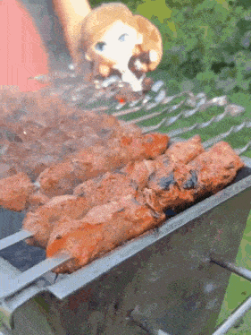 a person is grilling meat on skewers on a small grill