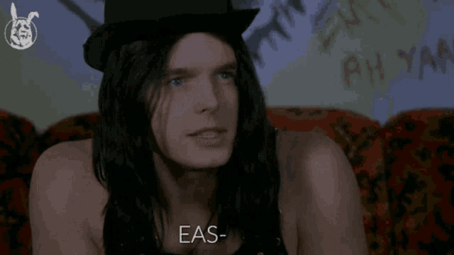 a man with long hair wearing a top hat is asking eas-ter
