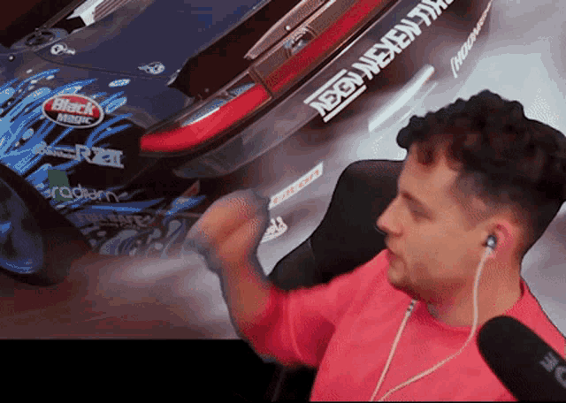 a man wearing ear buds is sitting in front of a car with a sticker on it that says black magic