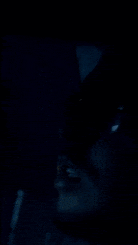a person wearing a watch with diamonds on their wrist in a dark room