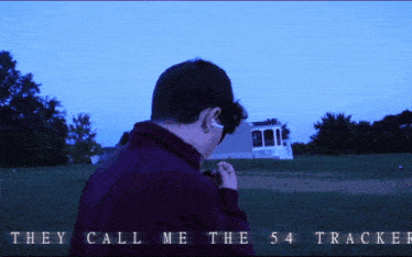 a man is standing in a field with the words " they call me the 54 tracker " on the bottom