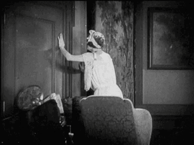 a woman in a white dress is sitting in a chair in a living room .