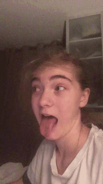 a young girl sticking her tongue out in a funny face