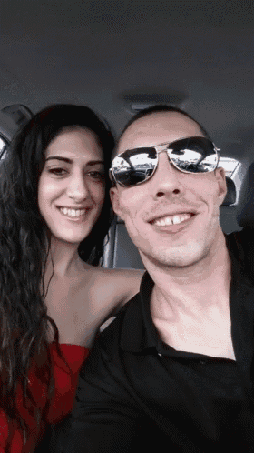 a man and a woman wearing sunglasses pose for a photo
