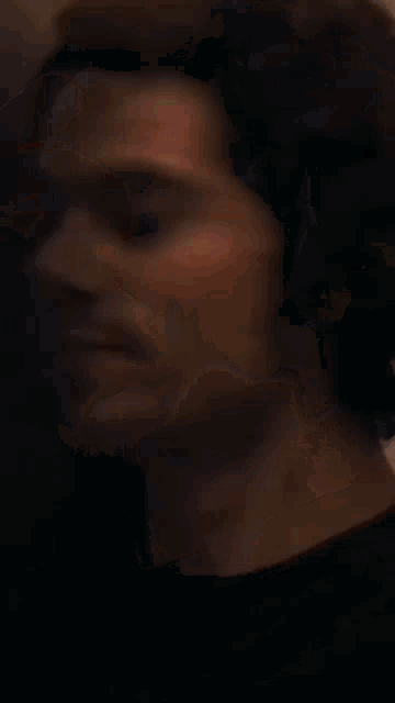 a close up of a man 's face with curly hair