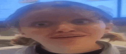 a close up of a woman making a funny face in a restaurant .
