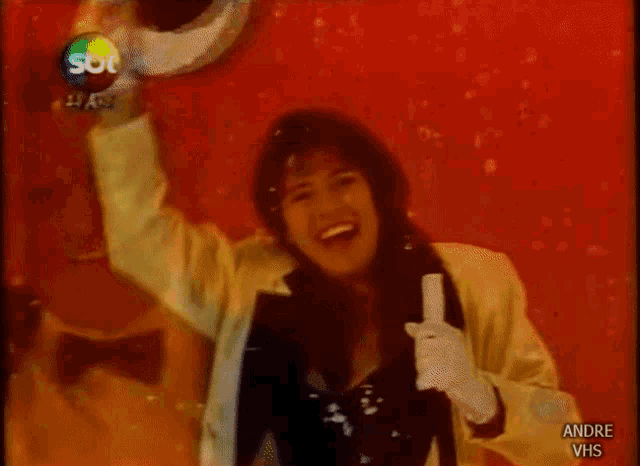a woman is giving a thumbs up in front of a red background with the words andre vhs below her