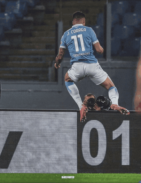 a soccer player with the number 11 on his jersey is jumping in the air