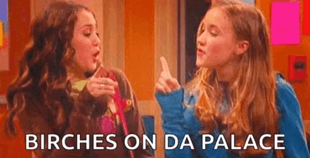 two girls are standing next to each other and one of them is pointing .