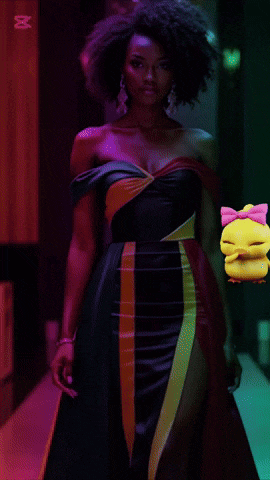 a woman in a green dress is holding a yellow duck with a pink bow on its head