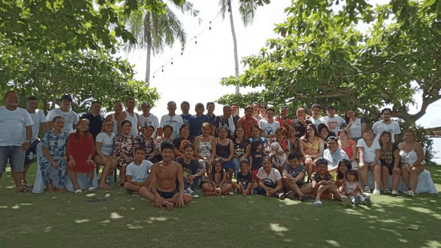 a group of people posing for a picture with one man wearing a shirt that says ' hawaii '
