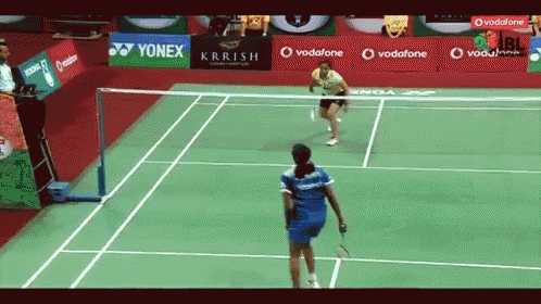 a badminton court with yonex and vodafone advertisements