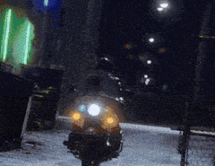 a person is riding a scooter down a dark alleyway at night
