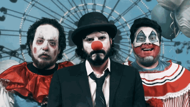 a group of clowns are posing for a picture in front of a ferris wheel